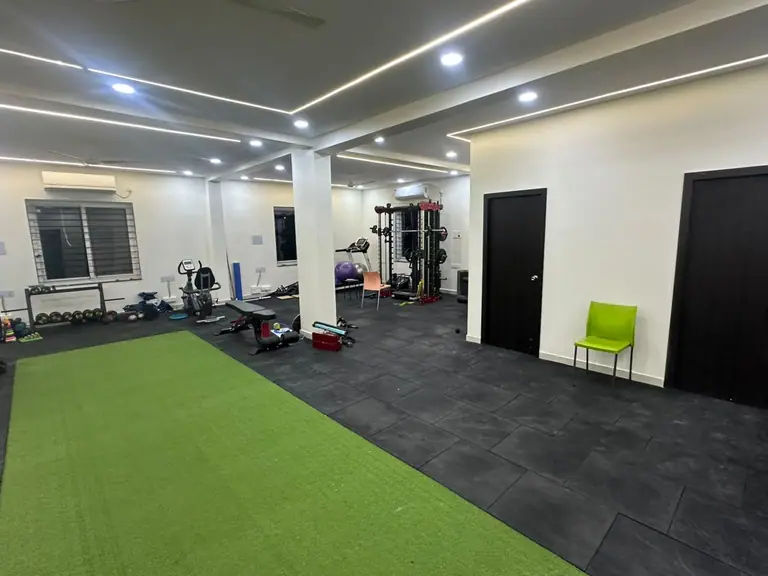 Spacious rehabilitation gym with turf and strength equipment at Mountain Fit Physiotherapy, Khajaguda